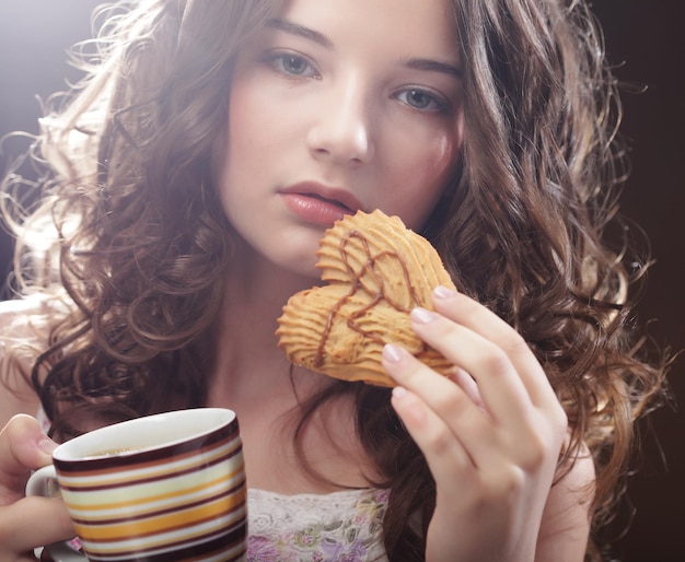 Mujer joven con café y galletas