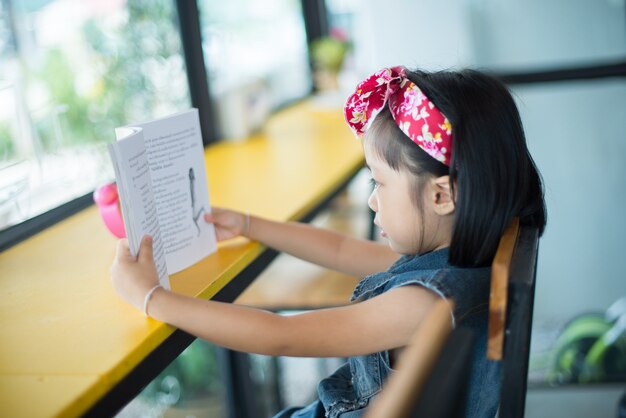 Mujer joven en un café leyendo un libro