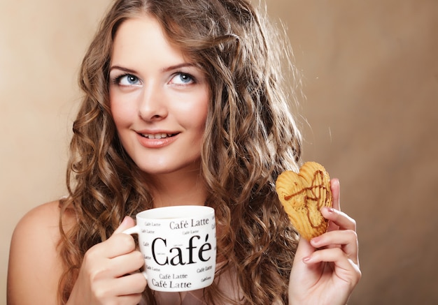 Mujer joven con café y pastel