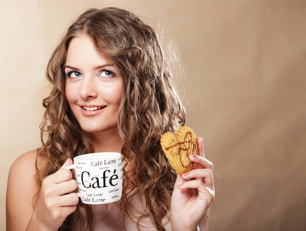 Mujer joven con café y pastel