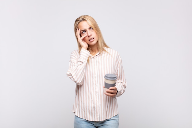 Mujer joven con un café sintiéndose aburrido