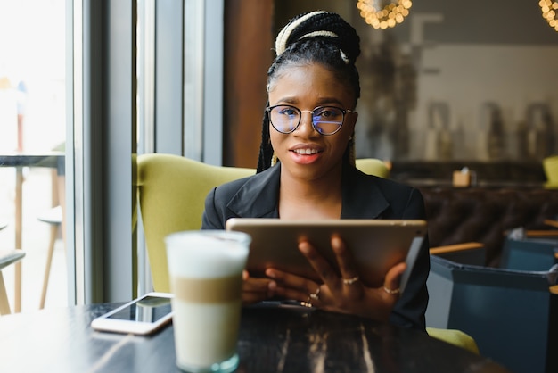 Mujer joven en un café con una tableta