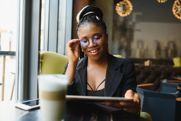 Foto mujer joven en un café con una tableta