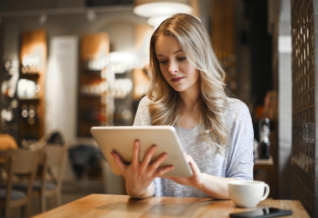 Mujer joven en un café con una tableta