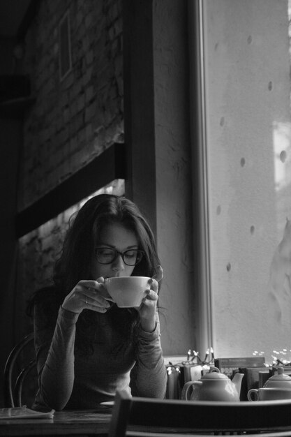 Foto mujer joven en la cafetería