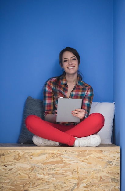 Foto mujer joven en una caja creativa trabajando en una tableta, negocio de inicio moderno interior de la sala de oficina