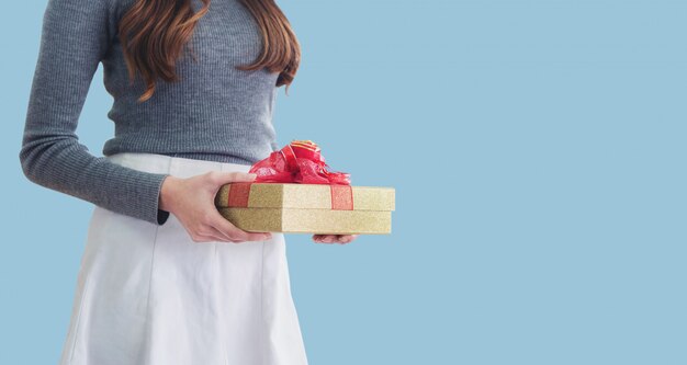 Mujer joven con caja de regalo, en azul