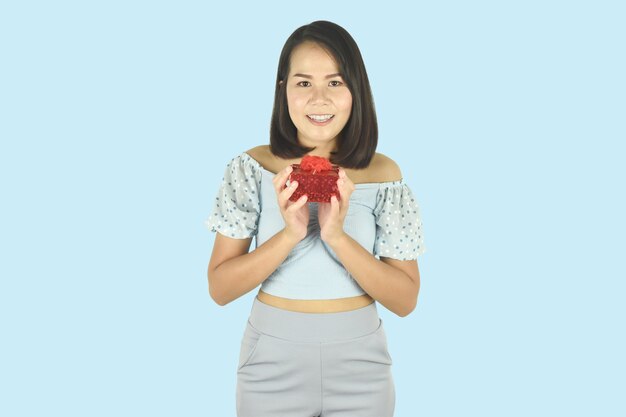 Mujer joven con caja de regalo roja presente para cumpleaños día de San Valentín concepto de año nuevo de Navidad