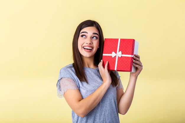 mujer joven con una caja de regalo roja en sus manos