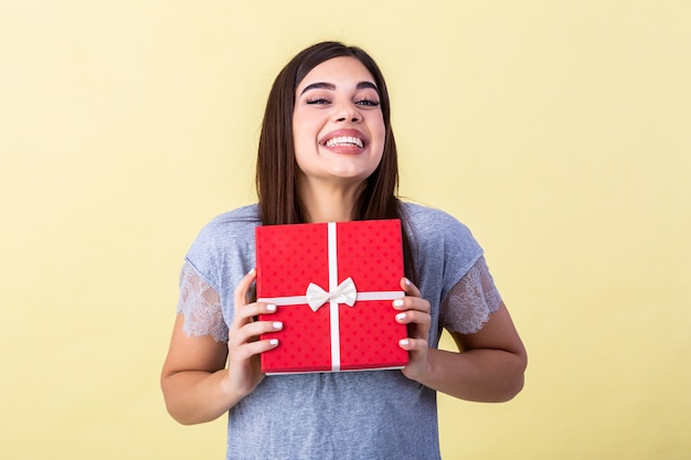 mujer joven con una caja de regalo roja en sus manos