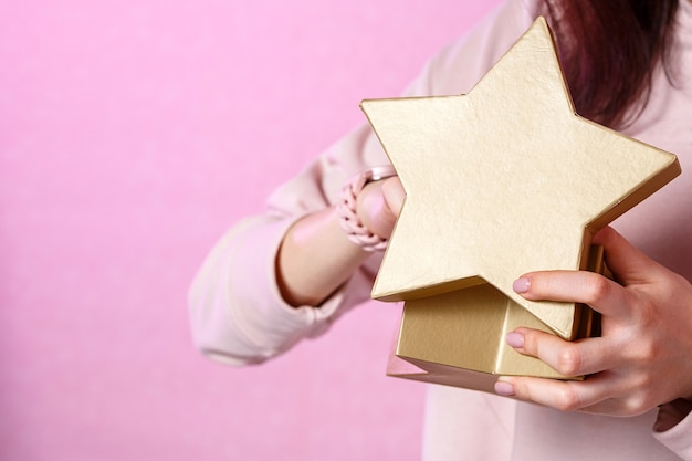 Una mujer joven con una caja de regalo en sus manos