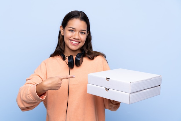 Mujer joven con cajas de pizza sobre pared aislada