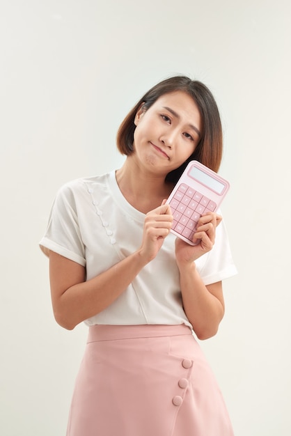 Mujer joven con calculadora, aislado sobre fondo blanco.