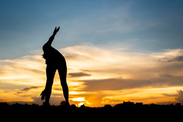 Mujer joven calentando al aire libre en el parque