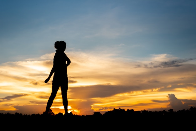 Mujer joven calentando al aire libre en el parque