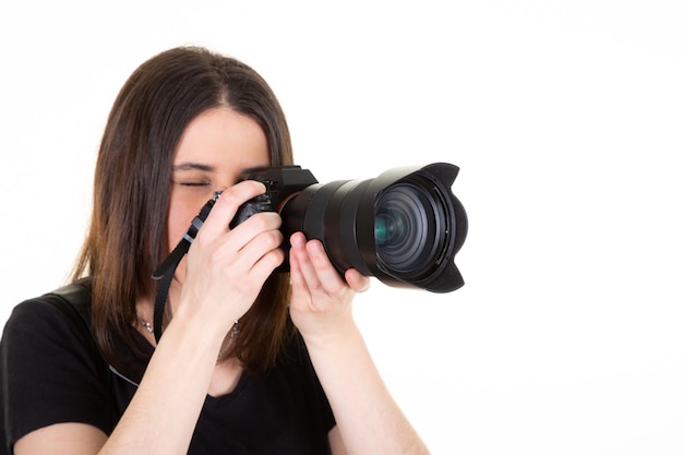 Mujer joven con cámara SLR digital profesional negro sobre fondo blanco.