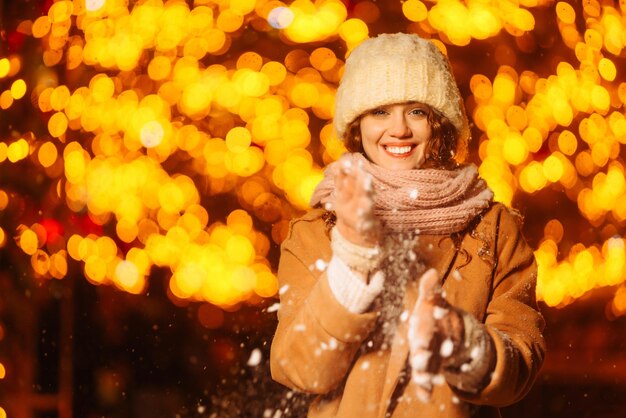 Foto mujer joven camina por la ciudad de invierno de noche luz alrededor vacaciones de moda de invierno descanso