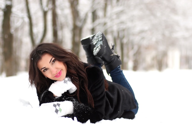 Una mujer joven camina en un parque de invierno al aire libre