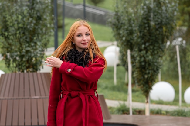 Mujer joven camina en el parque de otoño en un día fresco