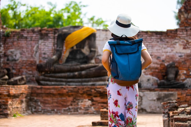 Una mujer joven camina en el viejo templo en Phra Nakhon Si Ayutthaya, Tailandia en un día relajante.