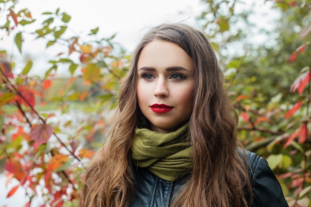 Mujer joven caminando en el parque de otoño al aire libre