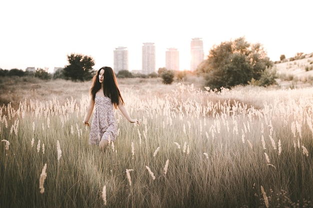 Mujer joven caminando entre las plantas en el campo