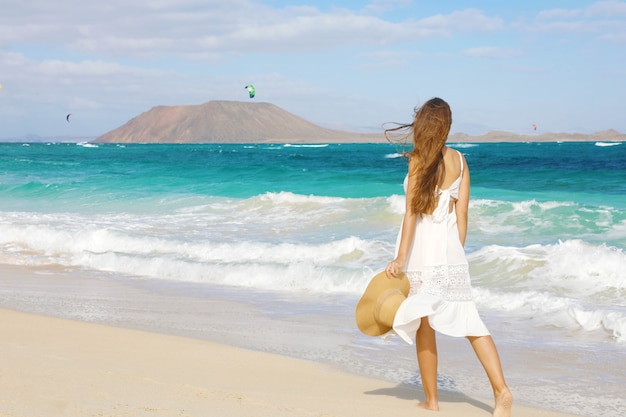 Mujer joven caminando por la playa salvaje de Corralejo, Fuerteventura, Islas Canarias