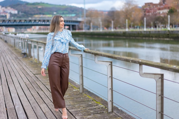 Mujer joven caminando por el río en el concepto de estilo de vida de la ciudad