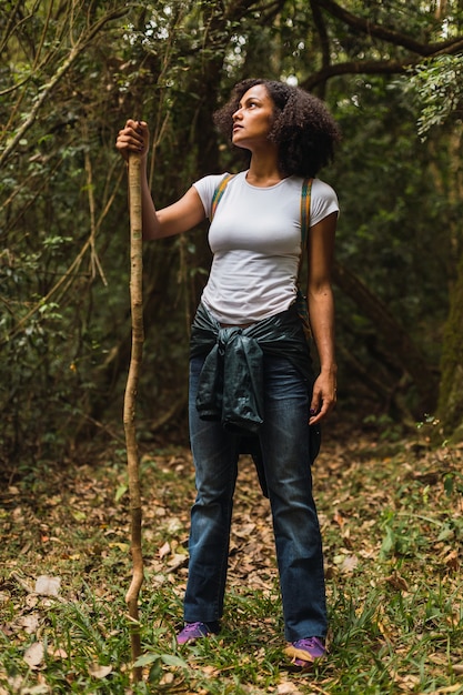 Mujer joven caminando por el sendero con una mochila