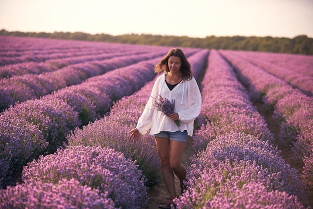 Mujer joven con camisa blanca en un hermoso campo de lavanda