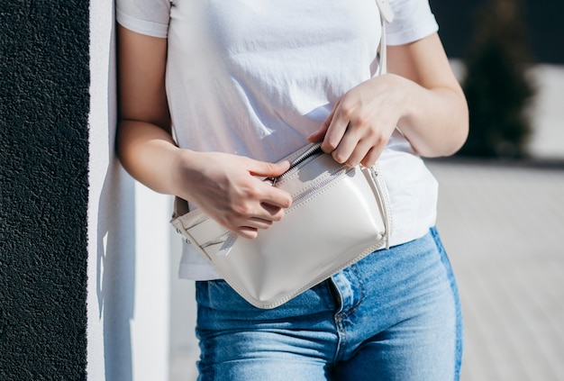 Foto mujer joven en camisa y jeans posando al aire libre