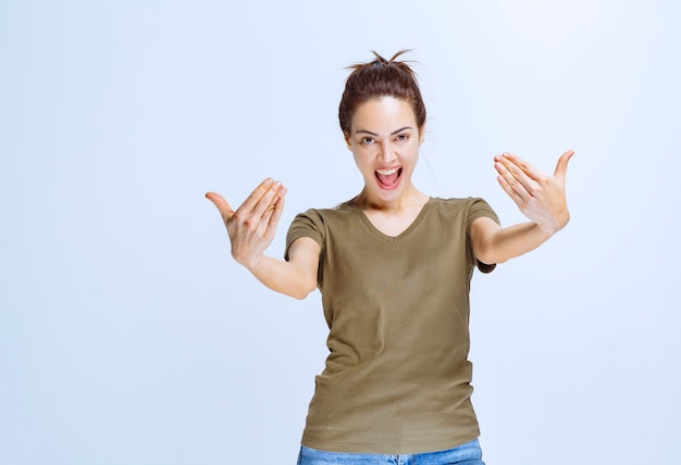 Foto mujer joven en camisa verde invitando a alguien