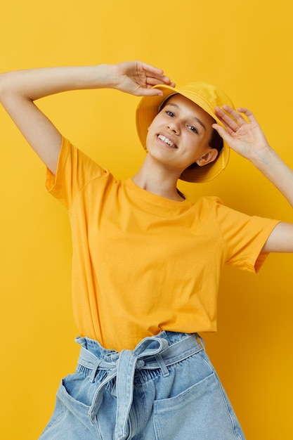 Mujer joven en una camiseta amarilla y sombrero emociones estilo de vida de verano inalterado