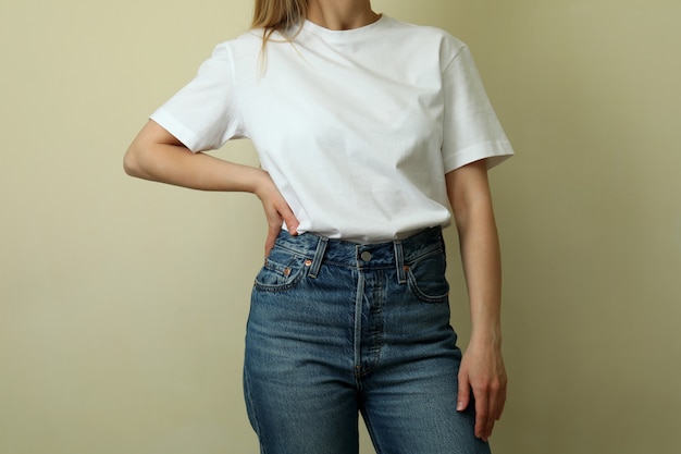 Mujer joven en camiseta en blanco sobre fondo beige