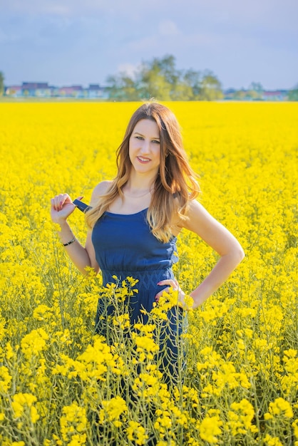 mujer joven en un campo de colza fondo amarillo azul como la bandera de ucrania