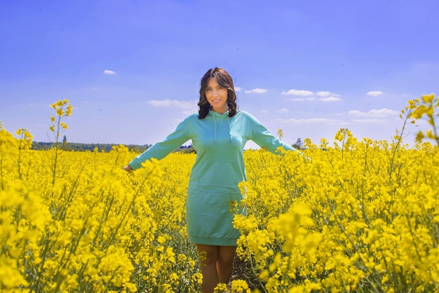 mujer joven en un campo de colza fondo amarillo azul como la bandera de ucrania