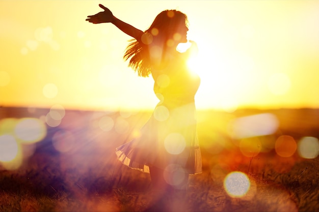 Mujer joven en campo bajo la luz del atardecer