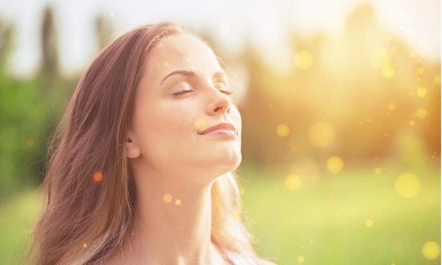 Mujer joven en el campo bajo la luz del atardecer