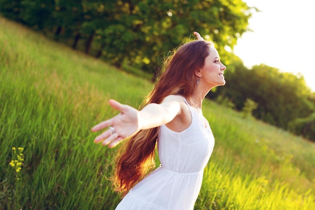 Mujer joven en el campo bajo la luz del atardecer