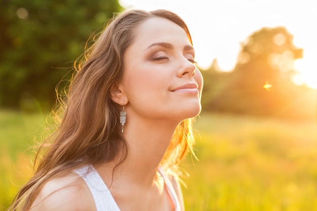 Mujer joven en campo bajo la luz del atardecer