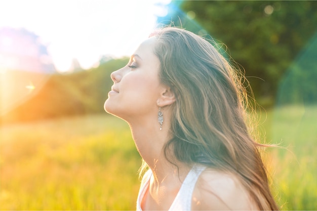 Mujer joven en campo bajo la luz del atardecer