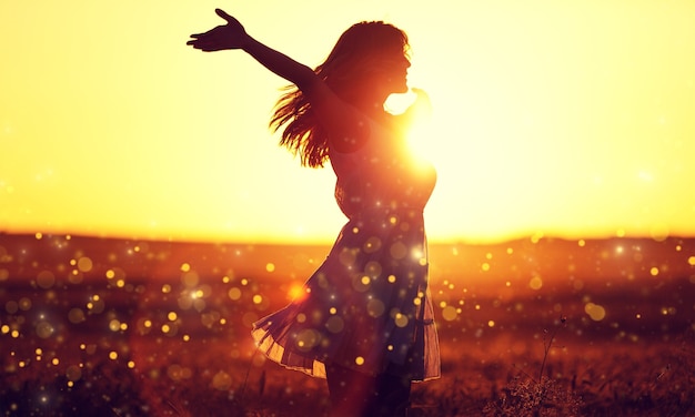 Mujer joven en campo bajo la luz del atardecer