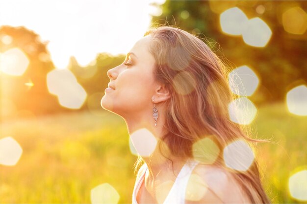 Mujer joven en el campo bajo la luz del atardecer