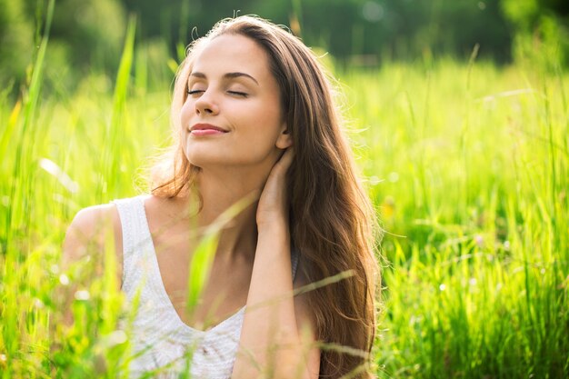 Mujer joven en campo bajo la luz del atardecer