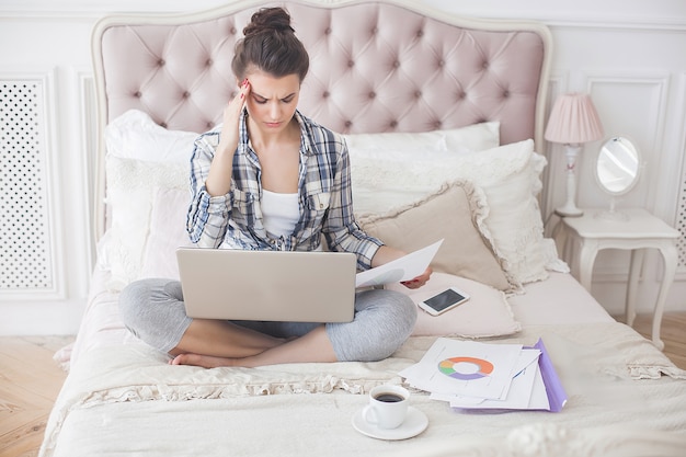 Foto mujer joven cansada trabajando en la computadora portátil