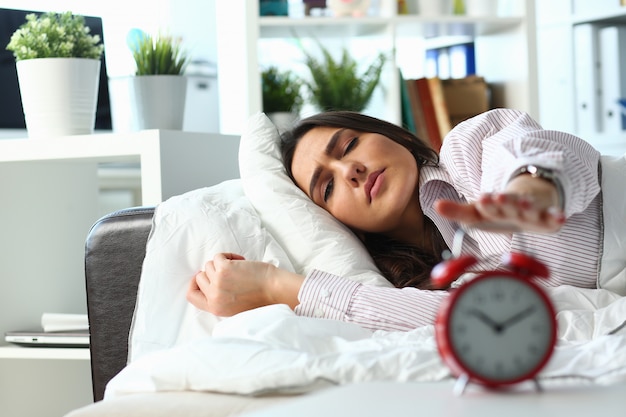 Mujer joven cansada tratando de dormir durante el día