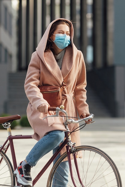 Mujer joven, en, cara, médico, máscara, equitación, bicicleta