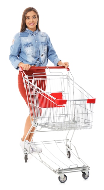 Mujer joven con carrito de compras vacío sobre fondo blanco.