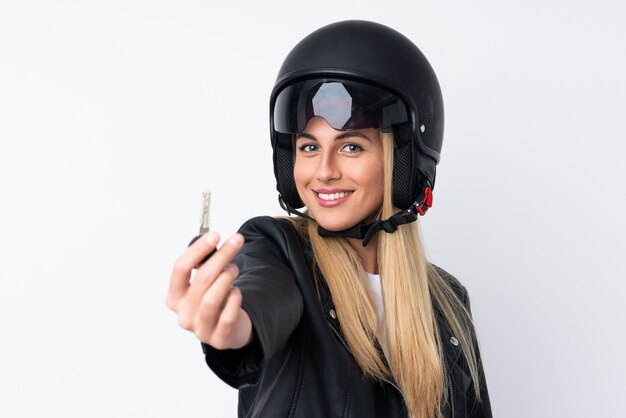 Mujer joven con un casco de moto sobre pared blanca aislada