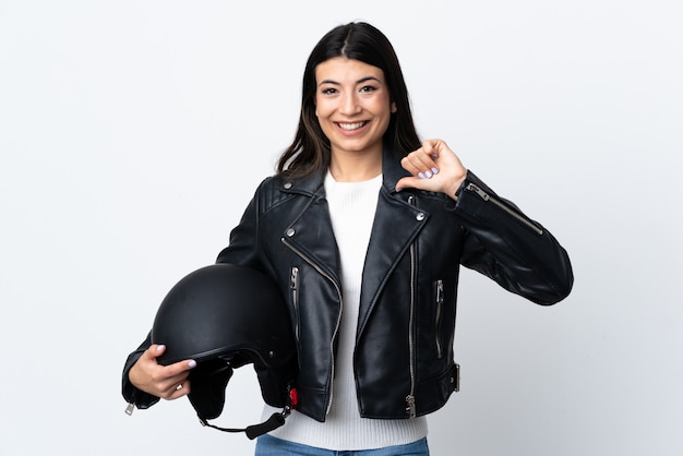 Mujer joven con un casco de motocicleta sobre blanco aislado orgulloso y satisfecho de sí mismo